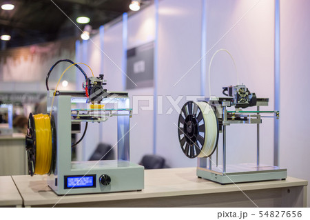Three dimensional 3D printers during work at modern technology exhibition Three dimensional 3D printers during work at modern technology exhibition 54827656