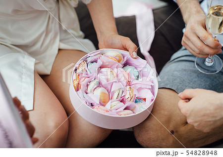 Portrait of beautiful happy couple man and woman are eating macaron biscuits 54828948