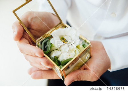 Groom holding wedding rings in box, the groom hold rings, wedding ring in groom hand. Engagement Groom holding wedding rings in box, the groom hold rings, wedding ring in groom hand. Engagement 54828973