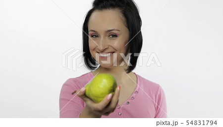 Young beautiful woman with big, fresh, juicy, green pear. Offer bite to viewer 54831794
