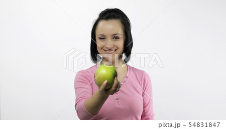 Young beautiful with green apple offer bite to viewer. Healthy nutrition Young beautiful with green apple offer bite to viewer. Healthy nutrition 54831847