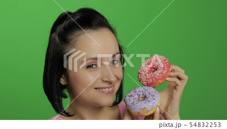 Happy beautiful young girl posing and having fun with donuts. Chroma key Happy beautiful young girl posing and having fun with donuts. Chroma key 54832253