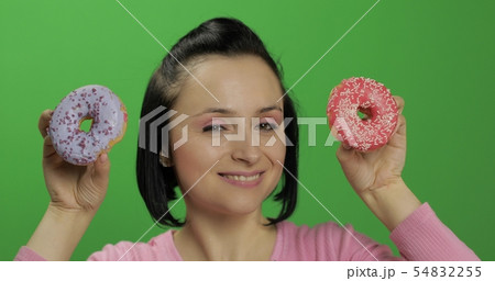 Happy beautiful young girl posing and having fun with donuts. Chroma key Happy beautiful young girl posing and having fun with donuts. Chroma key 54832255