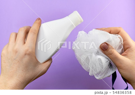 Bottle and washcloth in two hands. 54836358