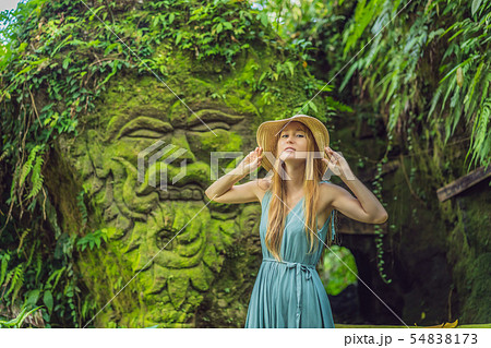 Young woman traveler in a Balinese garden overgrown with moss. Travel to Bali concept 54838173