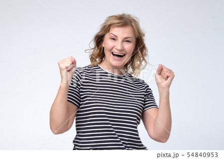 woman being excited and happy keeping mouth opened and fists up 54840953