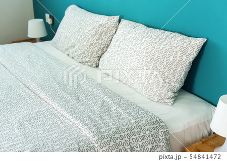 Pillow on head of bed and lamp on bedside table Pillow on head of bed and lamp on bedside table 54841472