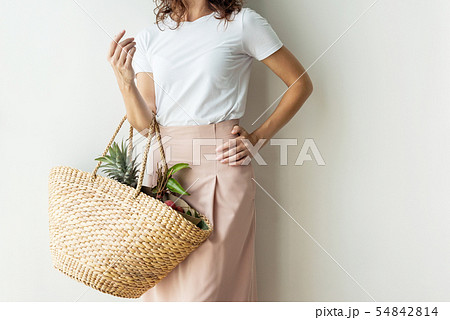 Young woman stands wattled bag near wall kinfolk. Young woman stands wattled bag near wall kinfolk. 54842814