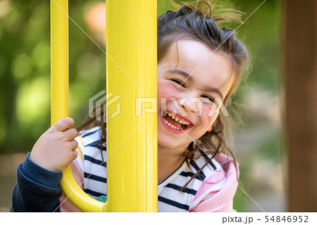 Cute girl enjoying on playground in the park in summertime. 54846952