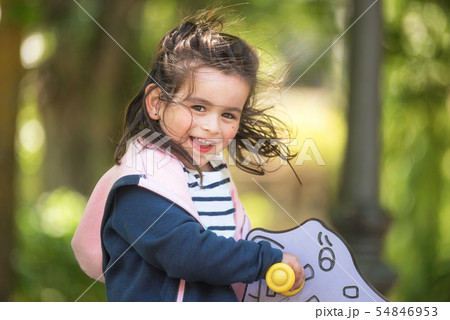 Cute girl enjoying on playground in the park in summertime. Cute girl enjoying on playground in the park in summertime. 54846953