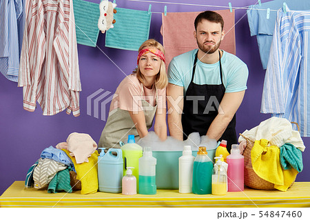 tired unhappy sad man and woman hate doing laundry 54847460