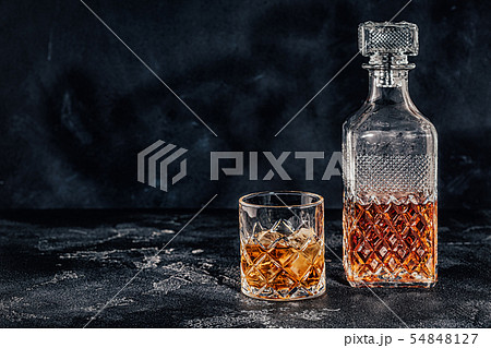 Glass of the whiskey with a square decanter 54848127