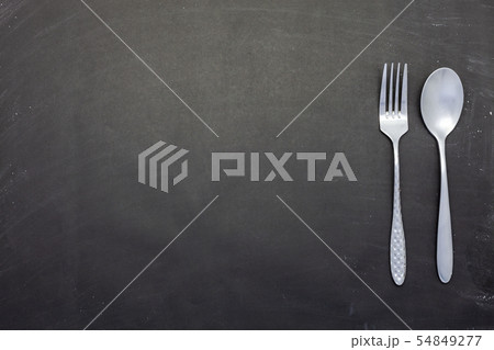 Stainless steel spoon and fork on black wood  54849277