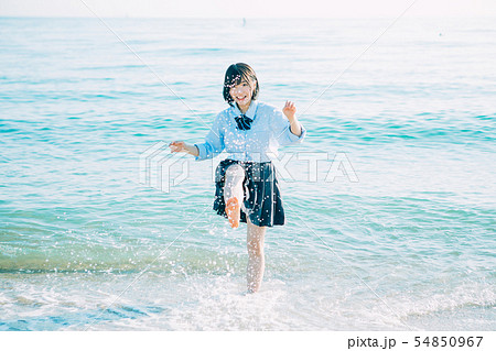 海辺ではしゃぐ女子高生の写真素材