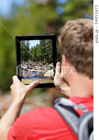 Hiking man taking nature pictures on tablet Hiking man taking nature pictures on tablet 54851672