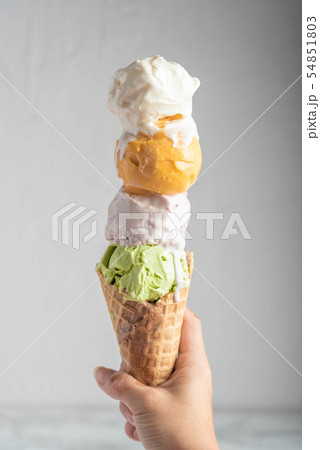 hand holding four scoops of ice cream in waffle 54851803