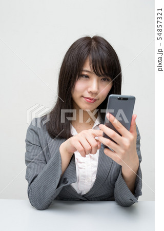 座ってスマホをいじる女性 座ってスマホをいじる女性 54857321