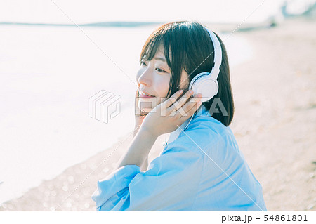 砂浜で音楽を聴く女子高生 54861801