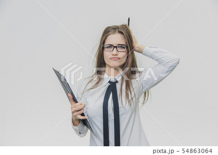 Adorable caucasian business woman is holding black paper holder or clipboard and looking at the Adorable caucasian business woman is holding black paper holder or clipboard and looking at the 54863064