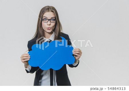 Young woman is holding a blue speech bubble in front of herself, which is cloud-shaped, isolated, on Young woman is holding a blue speech bubble in front of herself, which is cloud-shaped, isolated, on 54864313