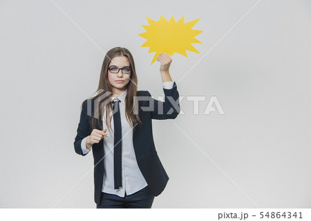 Young woman holding a yellow speech bubble, which is star-shaped, isolated, on the white background 54864341