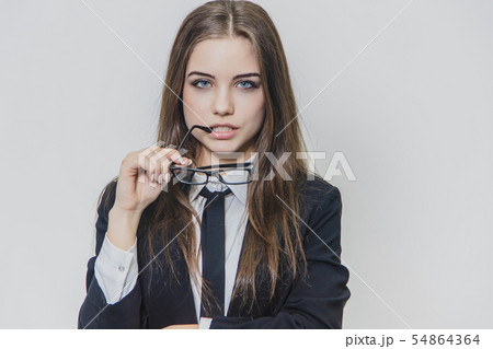 Charming sexy young businesswoman is holding glasses near her slightly open mouth. Charming sexy young businesswoman is holding glasses near her slightly open mouth. 54864364
