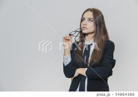 Beautiful businesswoman puts off herstylish glasses. Girl wears eyeglasses. Beautiful young woman is Beautiful businesswoman puts off herstylish glasses. Girl wears eyeglasses. Beautiful young woman is 54864366