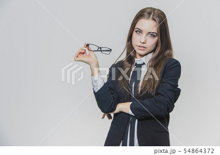 Beautiful businesswoman puts off herstylish glasses. Girl wears eyeglasses. Beautiful young woman is Beautiful businesswoman puts off herstylish glasses. Girl wears eyeglasses. Beautiful young woman is 54864372