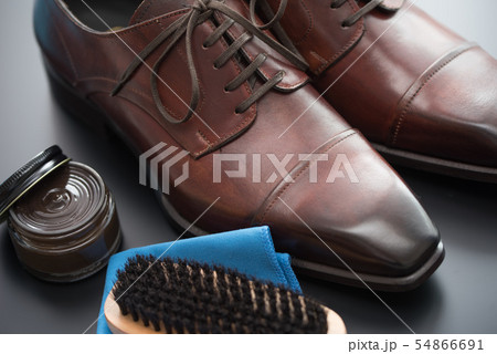 イタリア製の茶色い革靴とお手入れ用クリームとブラシ イタリア製の茶色い革靴とお手入れ用クリームとブラシ 54866691