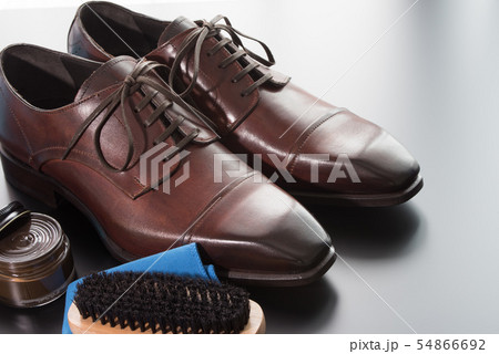 イタリア製の茶色い革靴とお手入れ用クリームとブラシ イタリア製の茶色い革靴とお手入れ用クリームとブラシ 54866692