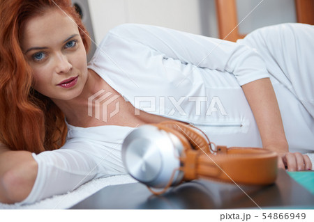 the girl is lying on the bed. next to headphones the girl is lying on the bed. next to headphones 54866949