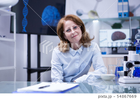 Portrait of successful scientist smiling to the camera in her laboratory office Portrait of successful scientist smiling to the camera in her laboratory office 54867669