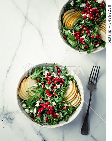 Vegan salad bowl with arugula, pear, pomegranate, cheese 54868258