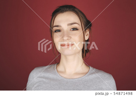 Portrait of young woman posing isolated over the red background. 54871498
