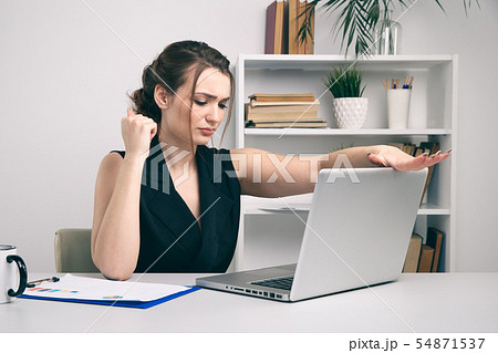 Nervous andangry woman in office closing her computer. Nervous andangry woman in office closing her computer. 54871537