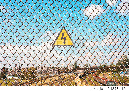 Yellow sign of danger on the fence 54873115