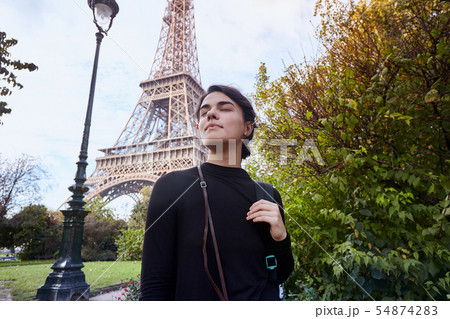 Beautiful smiling girl posing on the background of the Eiffel Tower. Paris, Champ de Mars 54874283