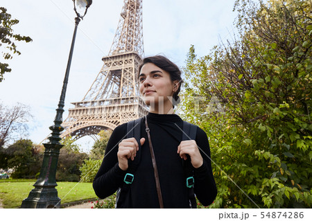 Beautiful smiling girl posing on the background of the Eiffel Tower. Paris, Champ de Mars Beautiful smiling girl posing on the background of the Eiffel Tower. Paris, Champ de Mars 54874286