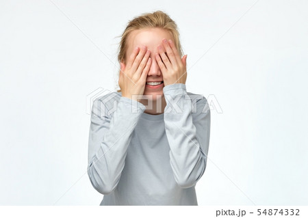 Young woman covering eyes with hands expecting to see surprise on your birthday. 54874332