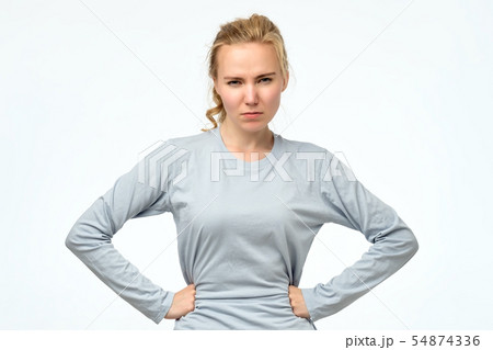 Displeased angry teenager holding hands on hips, frowning, looking with contempt 54874336