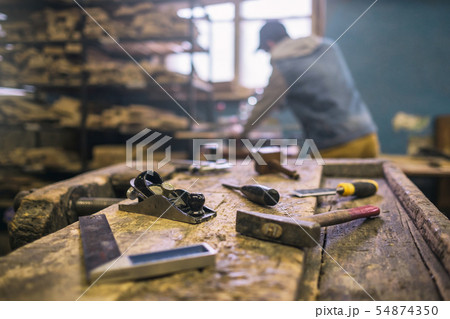Workshop with tools and blurred carpenter on background 54874350