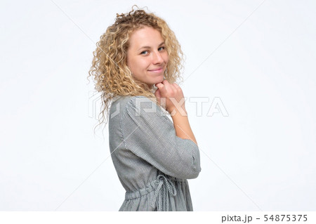 Curly haired woman in dress with perfect skin and smile. 54875375