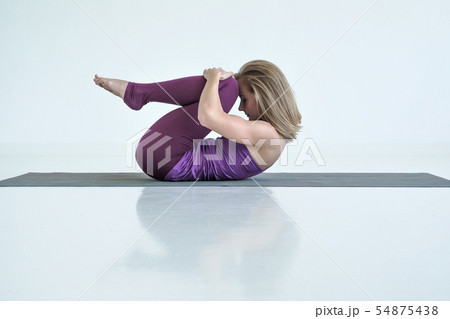 Woman practicing yoga, doing Knees to Chest exercise, Apanasana pose. 54875438
