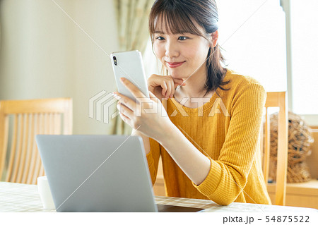 女性 スマホ 家 自宅 リビング 54875522