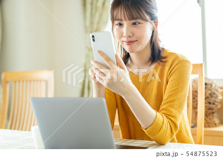 女性 スマホ 家 自宅 リビング 54875523