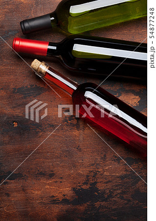 Various wine bottles on wooden table 54877248