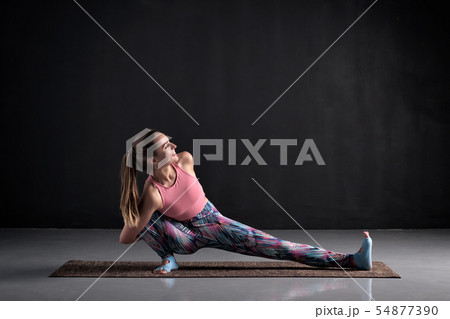 Beautiful woman doing Skandasana pose on yoga class, Studio shot. Beautiful woman doing Skandasana pose on yoga class, Studio shot. 54877390