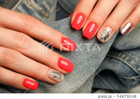 Bright neon red manicure on female hands on the background of jeans. Nail design. Beauty hands. Bright neon red manicure on female hands on the background of jeans. Nail design. Beauty hands. 54879248