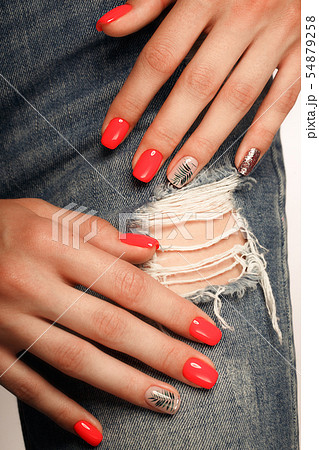 Bright neon red manicure on female hands on the background of jeans. Nail design. Beauty hands. Bright neon red manicure on female hands on the background of jeans. Nail design. Beauty hands. 54879258