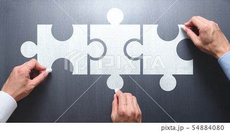 協力して解決策を見つけビジネスを成功させるイメージ。つながったジグソーパズルピースを黒板に描く3人の 協力して解決策を見つけビジネスを成功させるイメージ。つながったジグソーパズルピースを黒板に描く3人の 54884080